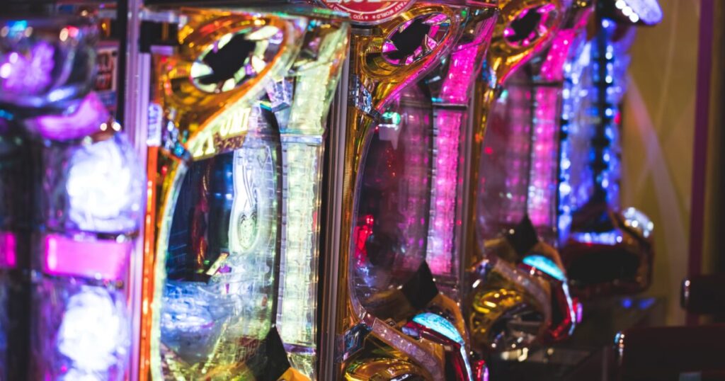 パチスロの煌びやかな筐体とライトアップされたホール内の様子